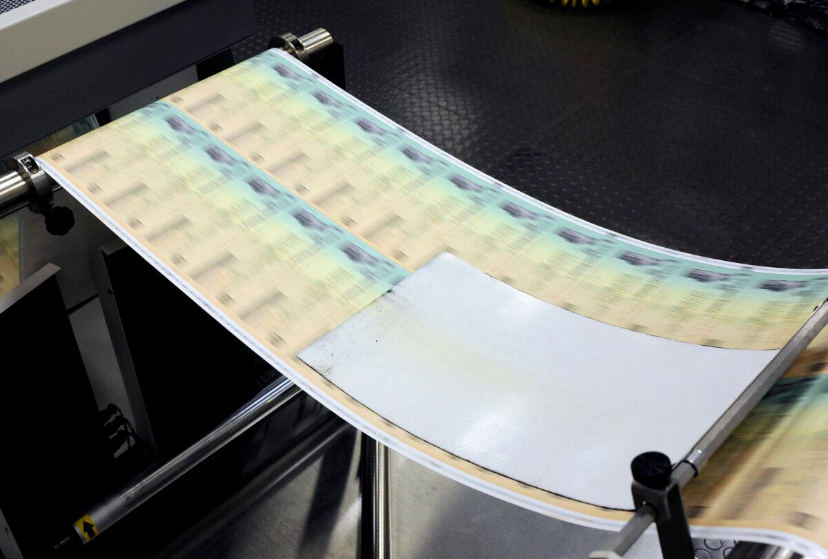 Blank checks are run through a printer at the U.S. Treasury printing facility in Philadelphia on July 18, 2011. (William Thomas Cain/Getty Images)