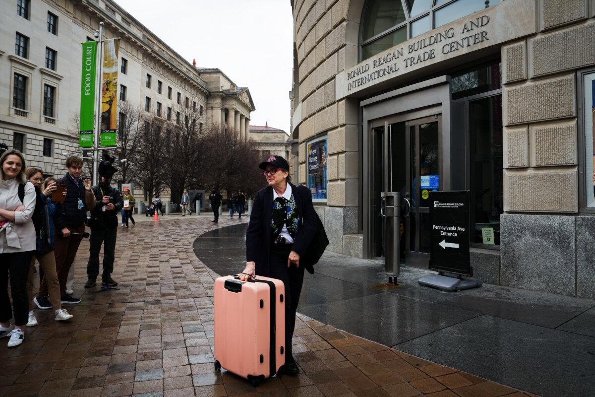 People stand outside in support of USAID employees leaving the building in Washington on Feb. 27, 2025. (Madalina Vasiliu/The Epoch Times)