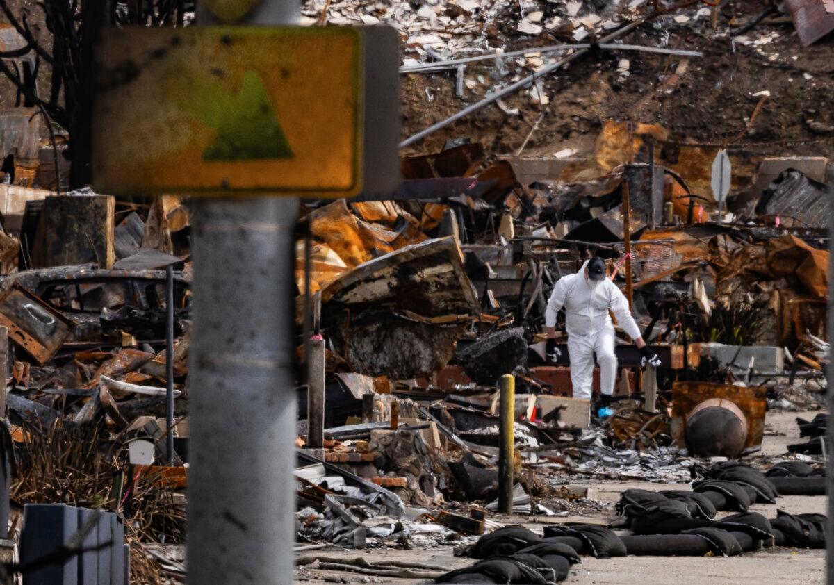 Men clean up debris leftover from the Palisades fire near Los Angeles, on Feb. 27, 2025. (John Fredricks/The Epoch Times)