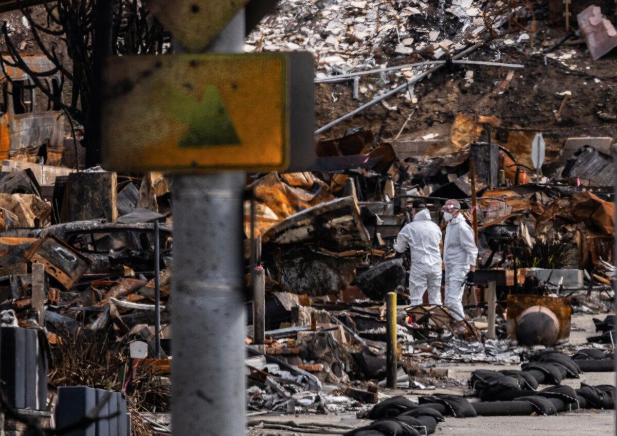 Men clean up debris leftover from the Palisades fire near Los Angeles on Feb. 27, 2025. (John Fredricks/The Epoch Times)