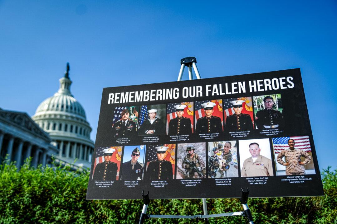 A sign with photos and names of the 13 service members killed in a terrorist attack at Abbey Gate is displayed during a news conference at the U.S. Capitol on Sept. 9, 2024. (Kent Nishimura/Getty Images)