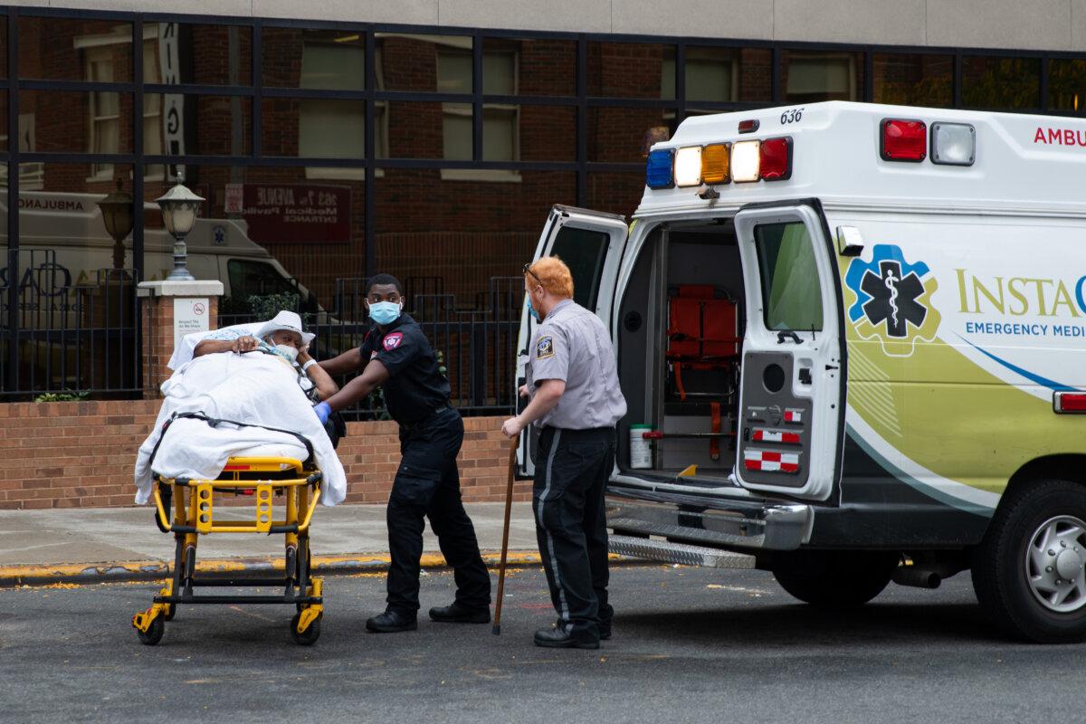 Health workers carry a patient into an ambulance in New York City on Oct. 7, 2020. (Chung I Ho/The Epoch Times)