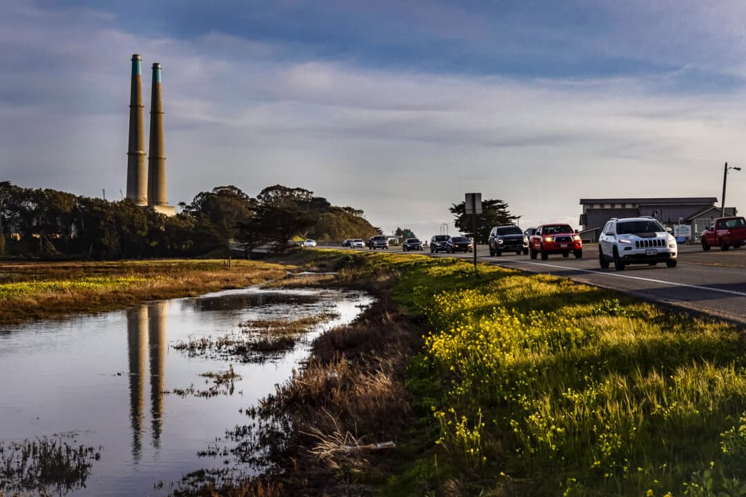 Cars drive past the Moss Landing Power Plant in Moss Landing, Calif., on Feb. 17, 2025. (John Fredricks/The Epoch Times)