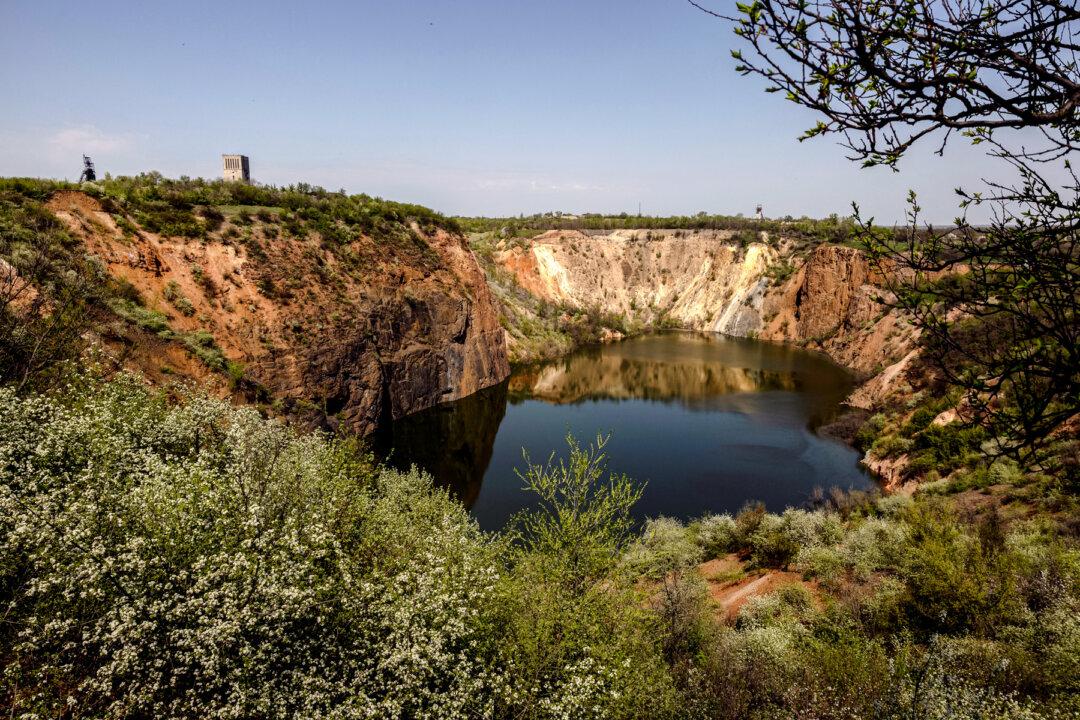 Flowers grow around a flooded open-pit mine that is a legacy of the Soviet Union's uranium industry, amid Russia's attack on Ukraine, in Zhovti Vody, Ukraine, on April 24, 2025. (Thomas Peter/Reuters)