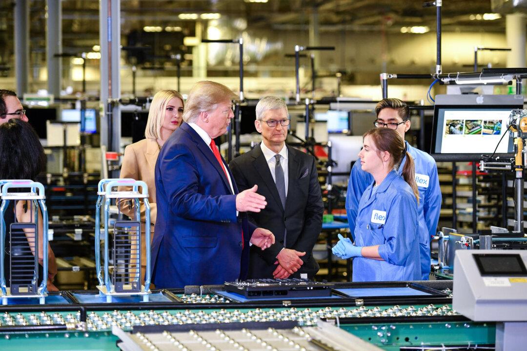 (L–R) Senior adviser to the president Ivanka Trump, President Donald Trump, and Apple CEO Tim Cook tour the Flextronics computer manufacturing facility where Apple’s MacBook Pros are assembled in Austin, Texas, on Nov. 20, 2019. (Mandel Ngan/AFP via Getty Images)