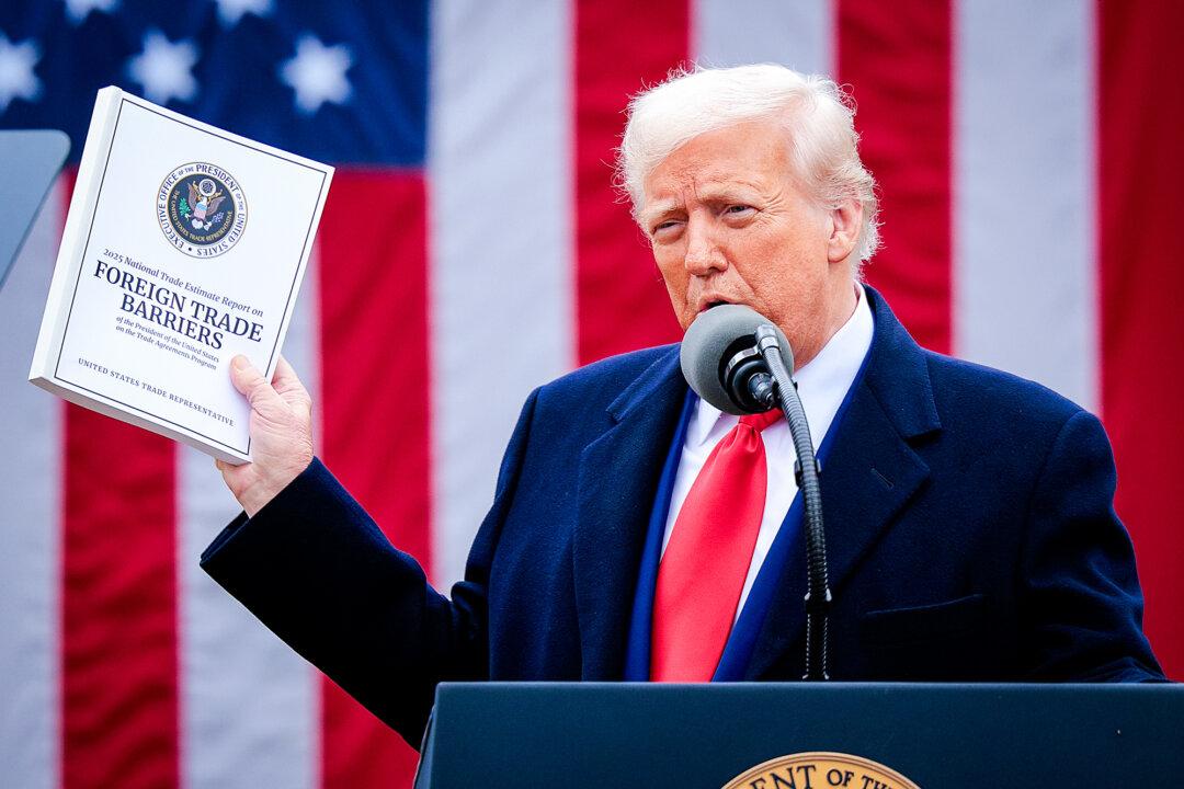 President Donald Trump holds up a copy of a 2025 National Trade Estimate Report as he speaks during a “Make America Wealthy Again” trade announcement event in the Rose Garden at the White House on April 2, 2025 (Chip Somodevilla/Getty Images)