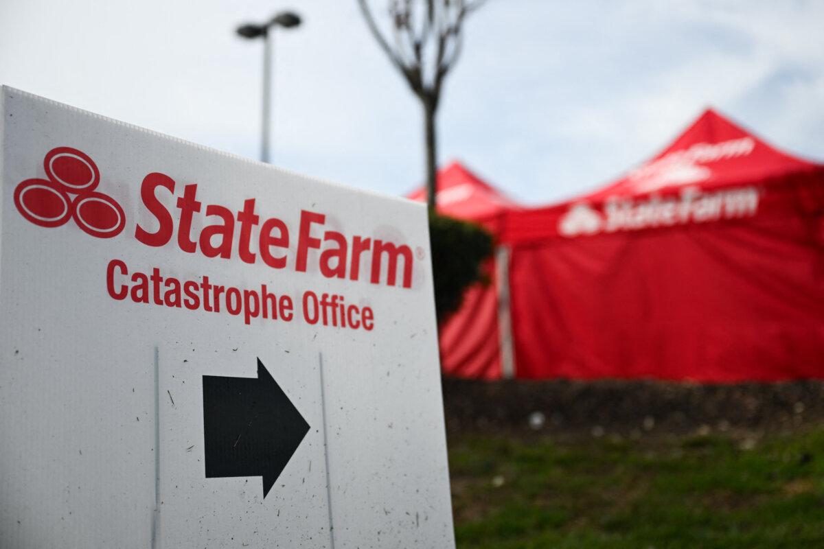 A State Farm sign points to a mobile office near the LA wildfire burn zone on Feb. 21, 2025. (Patrick T. Fallon/AFP via Getty Images)