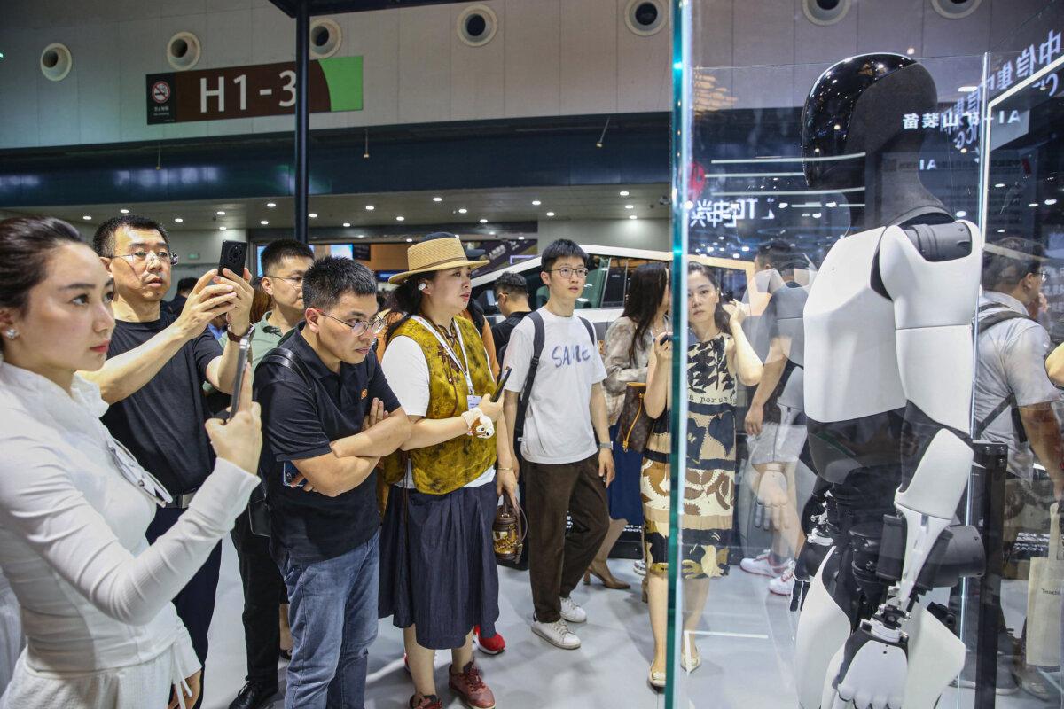 Visitors look at Tesla's humanoid robot Optimus in Shanghai, China, on July 5, 2024. (STR/AFP via Getty Images)