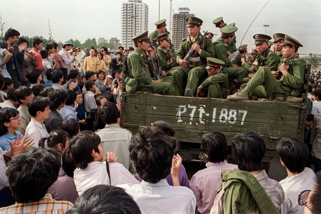 Pro-democracy demonstrators surround a group of People's Liberation Army soldiers on their way to Tiananmen Square in Beijing on May 20, 1989. (Catherine Henriette/AFP via Getty Images)