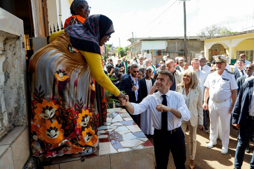 France's President Emmanuel Macron and his wife Brigitte greet residents as they visit with officials in the city center of Tsingoni during a visit to the French overseas territory of Mayotte, on April 21, 2025. Macron's five-day trip focused on France's strategy in the Indian Ocean includes visits to Mayotte, La Reunion, Madagascar, and Mauritius. Cyclone Chido devastated Mayotte, France's poorest territory in mid-December 2024, killing at least 120 people. (Ludovic Marin/AFP via Getty Images)