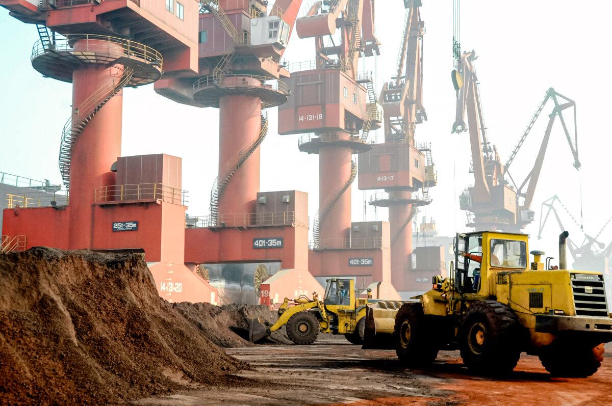 Workers transport soil containing rare earth elements for export at a port in Lianyungang, Jiangsu Province, China, on Oct. 31, 2010. (Stringer/Reuters/File Photo)