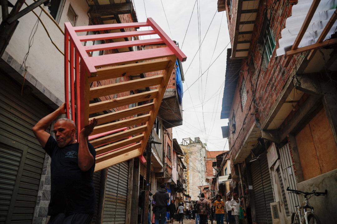 An employee of Sao Paulo's Housing and Urban Development Company carries belongings of residents of the Moinho favela as the state government evicts them from the shantytown in Sao Paulo on April 22, 2025. (Miguel Schincariol/AFP via Getty Images)