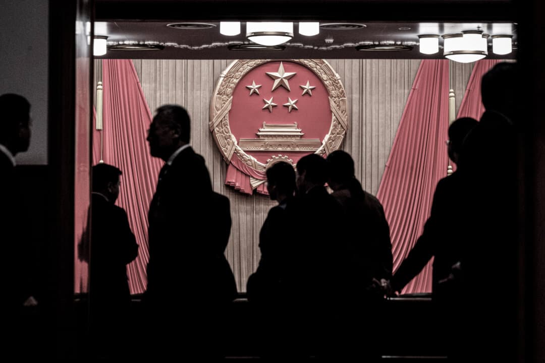 The National Emblem is seen as delegates and security gather at the entrance to the auditorium before the closing session of the National People’s Congress at the Great Hall of the People in Beijing on March 11, 2024. (Kevin Frayer/Getty Images)