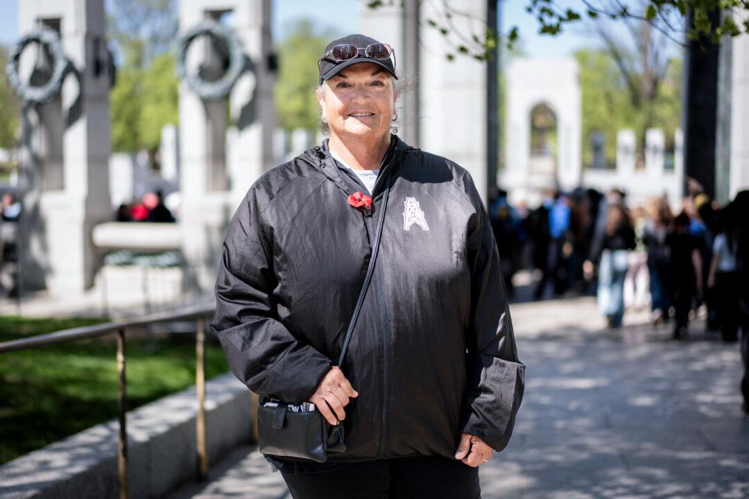 Tammy Cloud, 66, of Texas, walks by the World War II memorial as veterans visit the memorial in Washington on April 8, 2025. (Madalina Vasiliu/The Epoch Times)