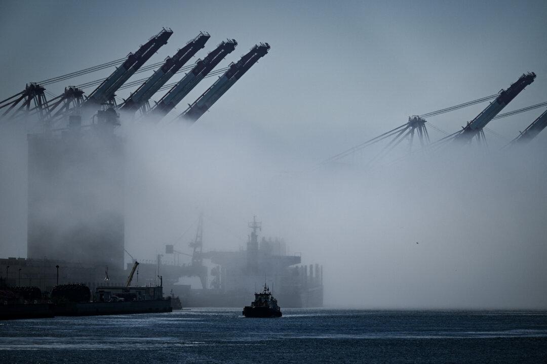 A tugboat sails through fog past cargo shipping cranes at the Port of Los Angeles in San Pedro, Calif., on April 10, 2025. “A truck driver can exit the vehicle and run from the danger,” Rosenberg said, but sailors on a tugboat “don’t have the option to pull over and get out.” (Patrick T. Fallon/AFP via Getty Images)
