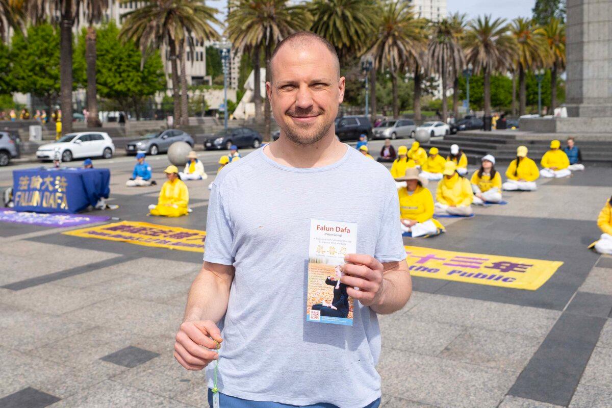 Daniel Dabek, co-founder of a cryptocurrency company, is a passerby at an event celebrating World Falun Dafa Day in San Francisco on May 3, 2025. (Lear Zhou/The Epoch Times)