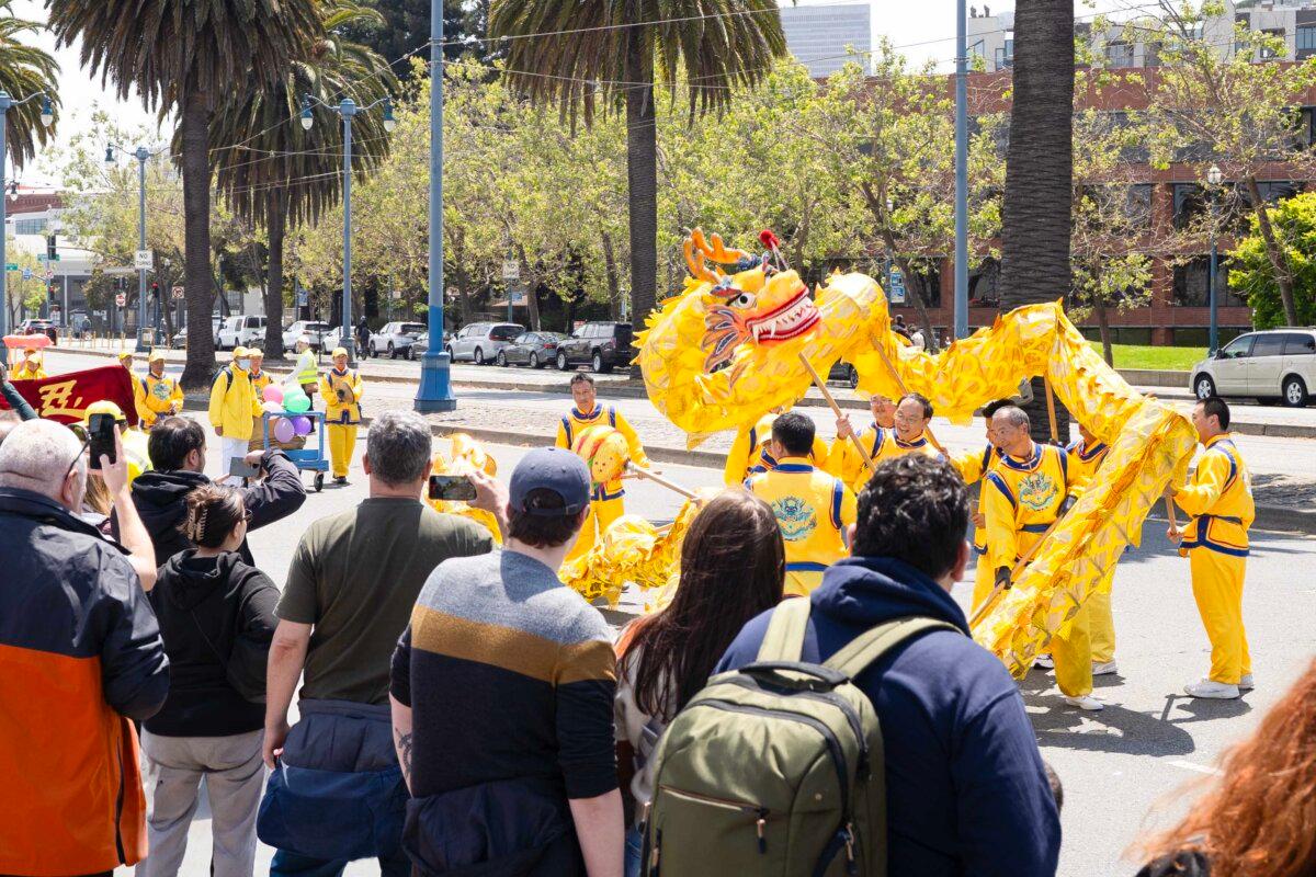 Passersby watch a dragon dance in a parade celebrating World Falun Dafa Day in San Francisco on May 3, 2025. (Gary Wang/The Epoch Times)
