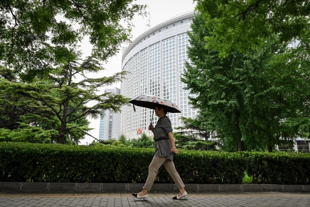 A woman walks past the Ministry of Foreign Affairs in Beijing on July 26, 2023. Most Chinese goods imported into the United States now face a 145 percent tariff, including a 20 percent duty targeting fentanyl. (Greg Baker/AFP via Getty Images)
