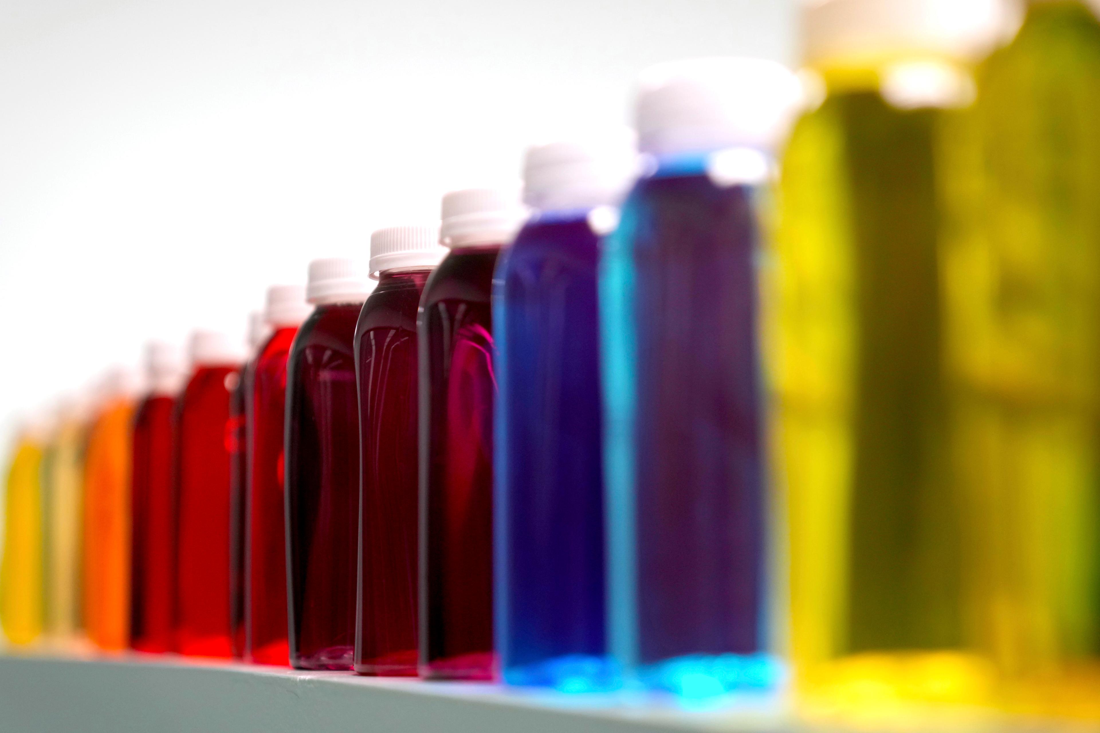 Bottles containing a variety of colored liquids sit on a shelf in a lab at Sensient Technologies Corp., a color additive manufacturing company, in St. Louis, on April 2, 2025. (Jeff Roberson/AP Photo)