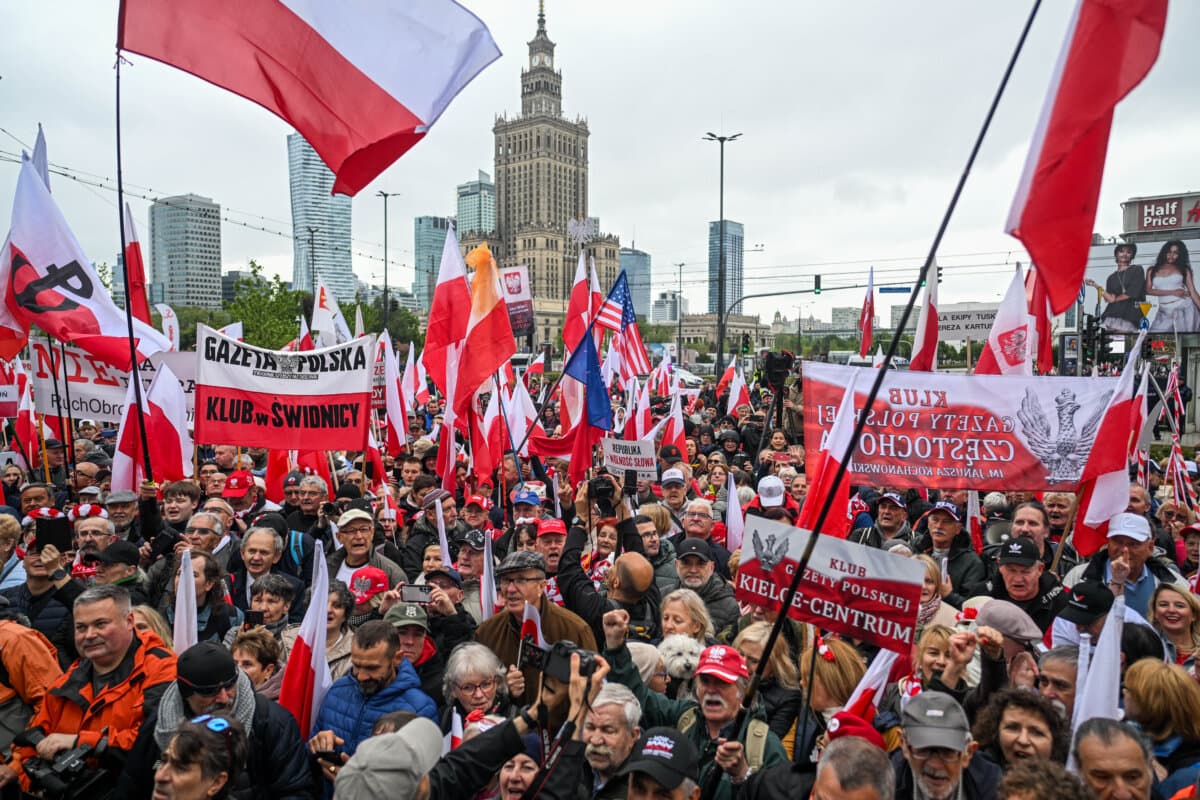 People hold banners and the Polish national flag during a protest against immigration, in Warsaw, Poland, on May 10, 2025. (Omar Marques/Getty Images)
