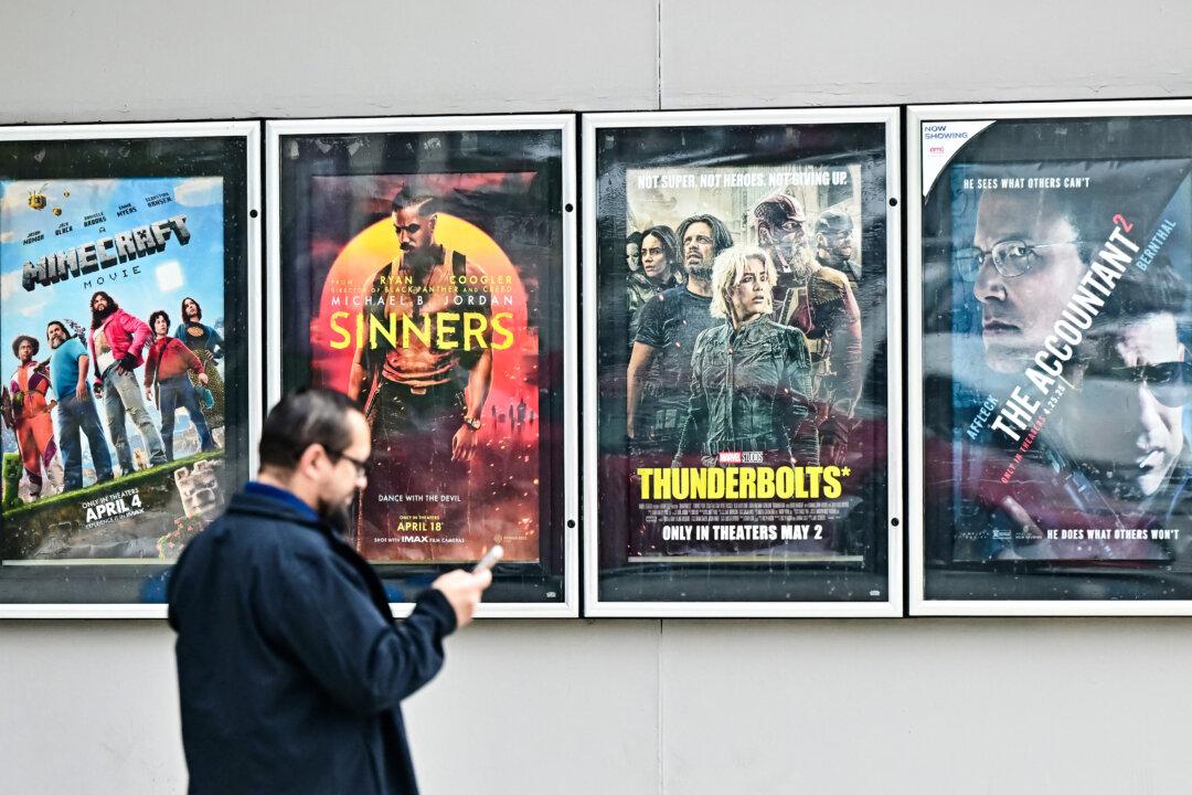 A man walks past movie posters at an AMC Theater in Montebello, Calif., on May 5, 2025. (Frederic J. Brown/AFP via Getty Images)