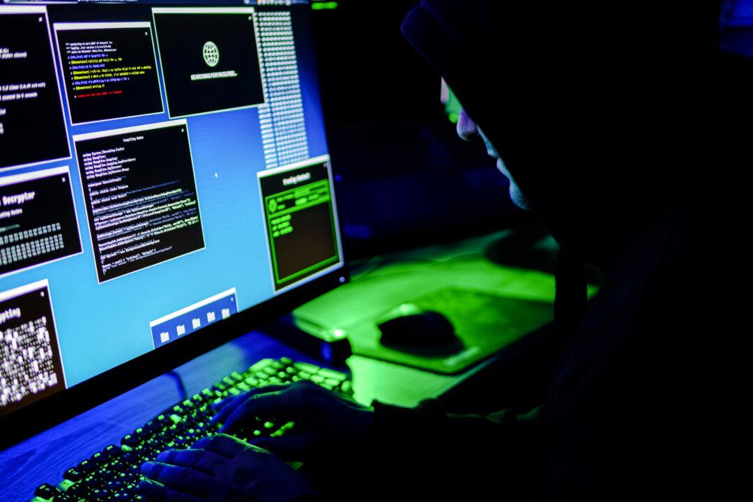 In this photo illustration, a hacker types on a computer keyboard on May 13, 2025. (Anna Varavva/The Epoch Times)
