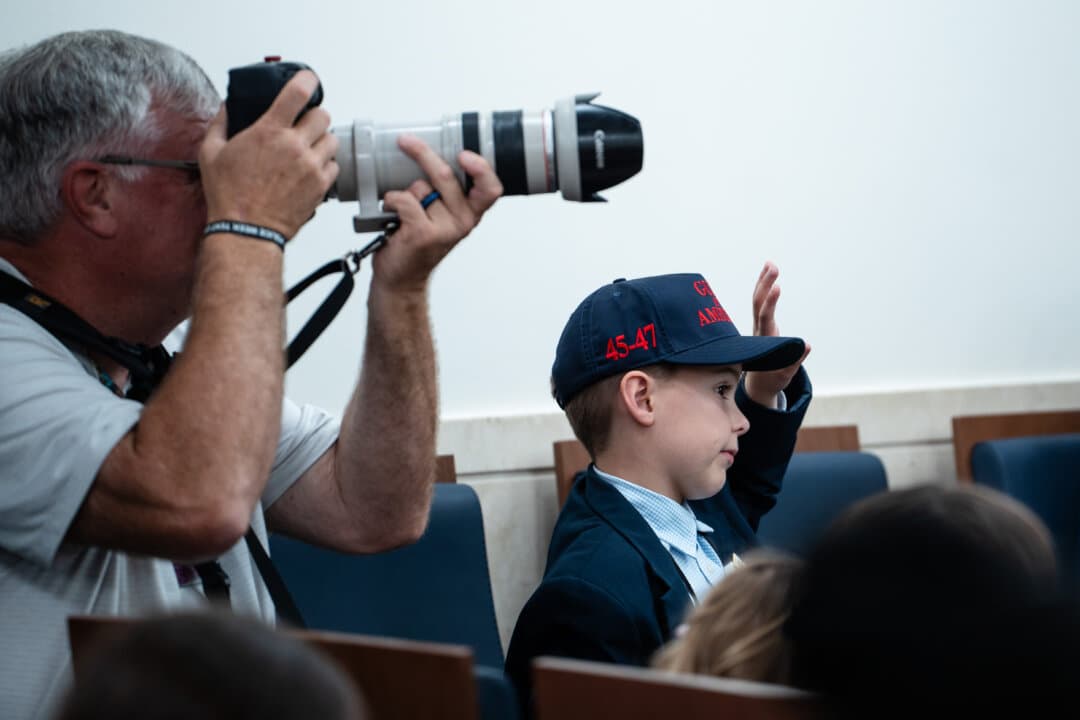 A boy raises his hand to ask a question during a mock press conference with White House press secretary Karoline Leavitt during Take Our Sons and Daughters to Work Day in the press briefing room of the White House on May 20, 2025. (Madalina Vasiliu/The Epoch Times)