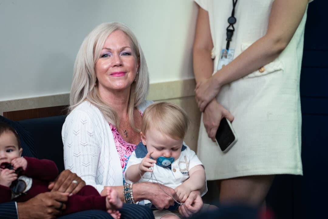 White House press secretary Karoline Leavitt's mother, Erin Leavitt, holds Karoline's son, Nicholas Riccio, during Take Our Sons and Daughters to Work Day in the press briefing room of the White House on May 20, 2025. (Madalina Vasiliu/The Epoch Times)