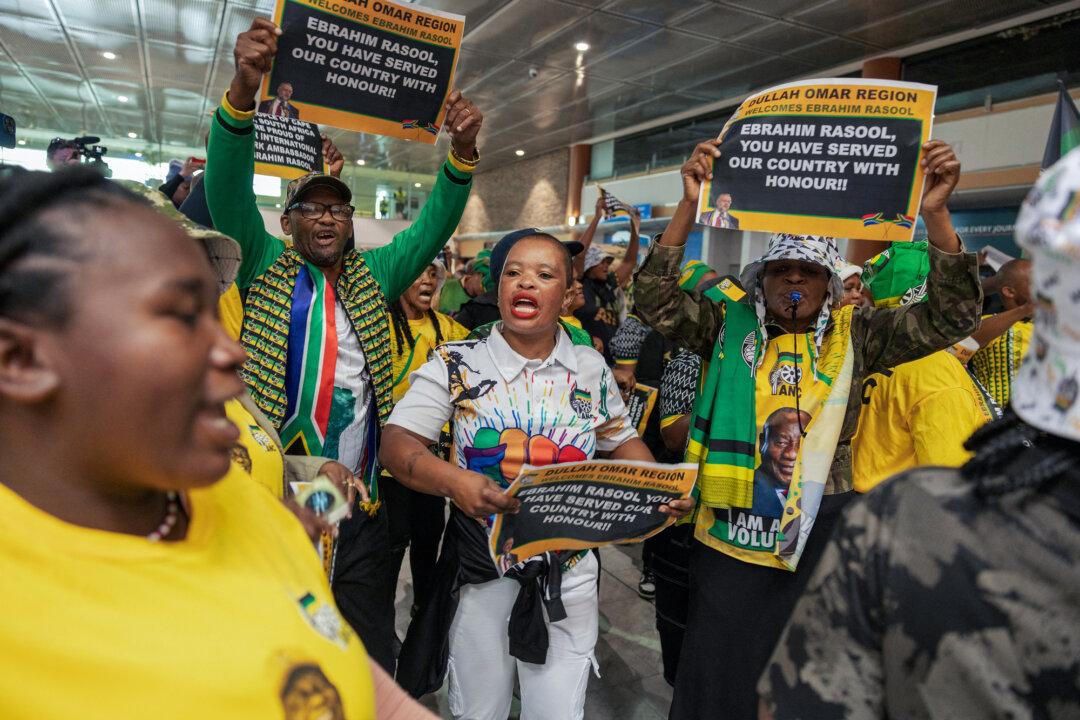 African National Congress, South African Communist Party, and South African Trade Union members sing and dance while awaiting the arrival of former South African Ambassador to the United States Ebrahim Rasool at Cape Town International Airport in Cape Town, South Africa, on March 23, 2025. (Gianluigi Guercia/AFP via Getty Images)