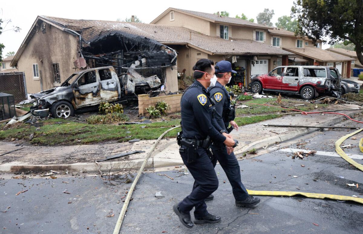 Police officers search the site where a small plane crashed on a San Diego, California, residential street on May 22, 2025. (Photo by Sandy Huffaker/AFP via Getty Images)