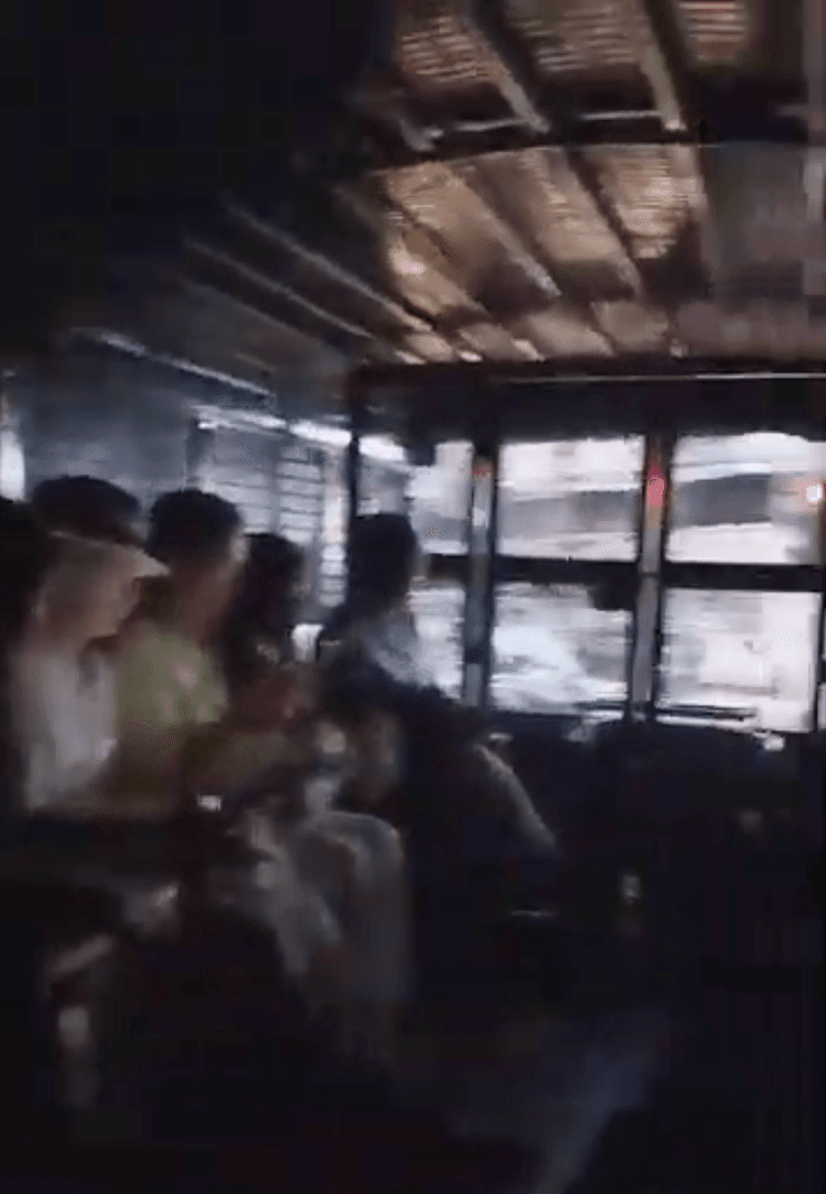 Falun Gong practitioners sit in a police van in Kuala Lumpur, Malaysia, on April 13, 2025. (The Epoch Times)
