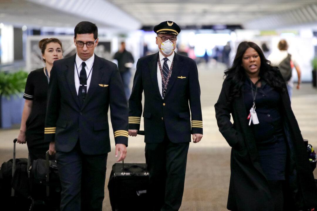 A United Airlines flight crew walks through the terminal at San Francisco International Airport in San Francisco on April 12, 2020. (Justin Sullivan/Getty Images)