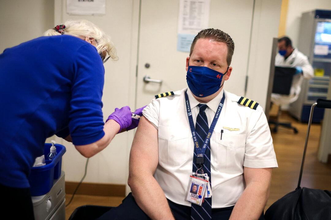 United Airlines pilot Steve Lindland receives a COVID-19 vaccine from nurse Sandra Manella at United's on-site clinic at O'Hare International Airport in Chicago on March 9, 2021. (Scott Olson/Getty Images)
