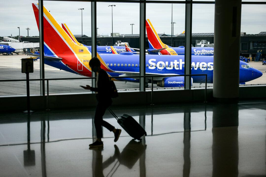 A traveler walks past a Southwest Airlines airplane as it taxies from a gate at Baltimore/Washington International Thurgood Marshall Airport in Baltimore on Oct. 11, 2021. (Kevin Dietsch/Getty Images)