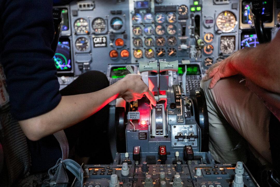 Chin-ting Chou (L) of Taiwan and Nemanja Nedelikovic of Serbia take a training course on a 737 jet simulator at the Pan Am Flight Academy in Miami Springs, Fla., on May 19, 2022. (Joe Raedle/Getty Images)