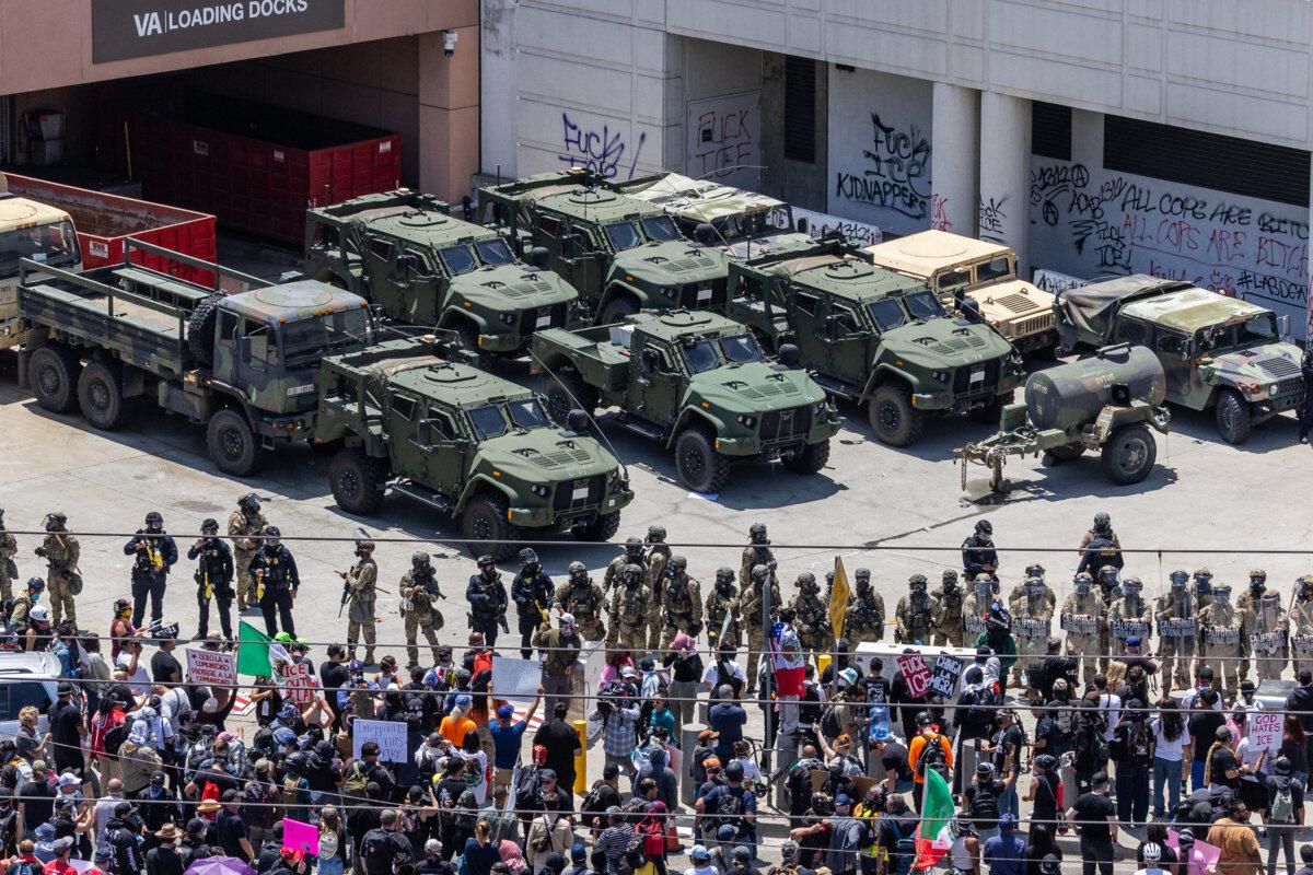 Protestors confront federal agents and California National Guardsmen in Los Angeles on June 8, 2025. (John Fredricks/The Epoch Times)