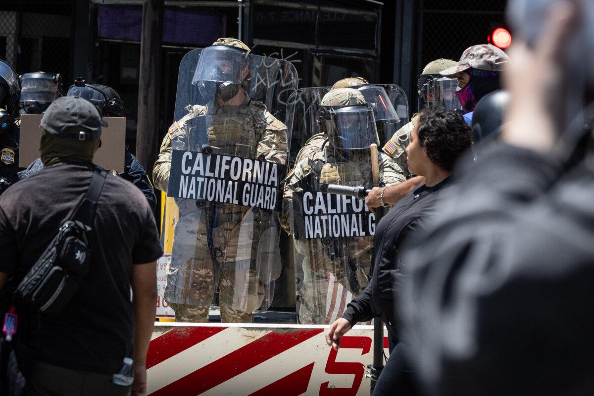 Protesters confront federal agents and California National Guardsmen in Los Angeles on June 8, 2025. (John Fredricks/The Epoch Times)