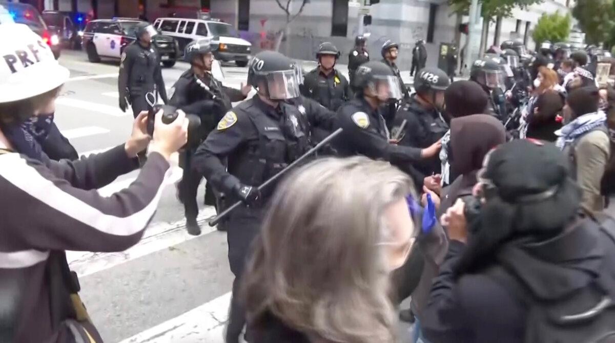 Protesters confront police in San Francisco on June 8, 2025, in a still from video. (AP/Screenshot via The Epoch Times)