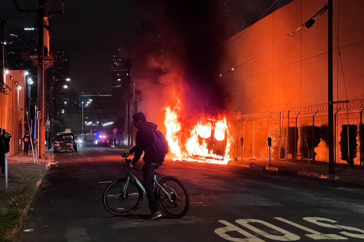 A car burns in downtown Los Angeles on June 8, 2025. (Melina Chan/The Epoch Times)