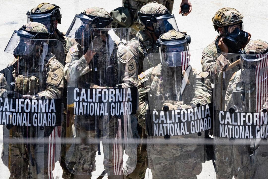 Protesters confront federal agents and California Army National Guardsmen in Los Angeles on June 8, 2025. (John Fredricks/The Epoch Times)