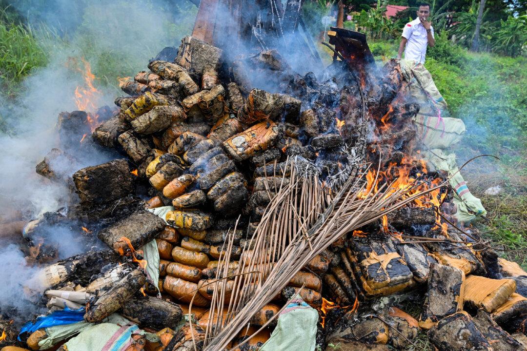 Police officers burn various drugs seized by law enforcement, during a press conference at regional police headquarters in Banda Aceh, Indonesia, on June 12, 2025. (Chaideer Mahyuddin/AFP via Getty Images)