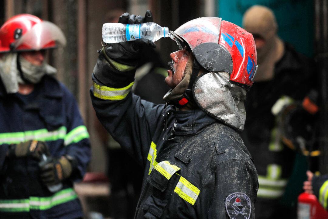 A firefighter cools off during a fire in the Shorja market in old Baghdad, Iraq, on June 12, 2025. (Ahmad Al-Rubaye/AFP via Getty Images)