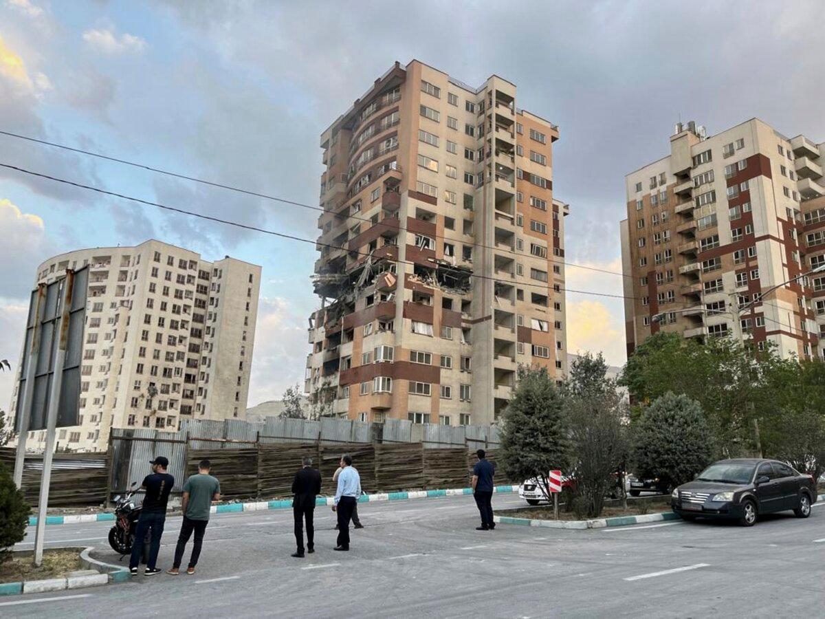 Residents watch a damaged apartment in Tehran, Iran, early on June 13, 2025. Israel attacked Iran's capital early Friday, with explosions booming across Tehran.(AP Photo/Vahid Salemi)