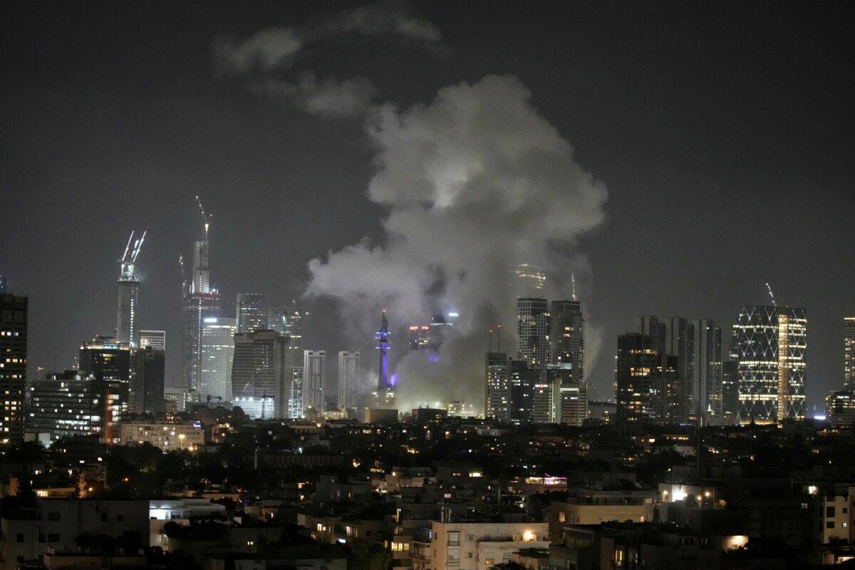 Smoke rises after a missile attack in Tel Aviv, Israel, on June 13, 2025. (AP Photo/Leo Correa)