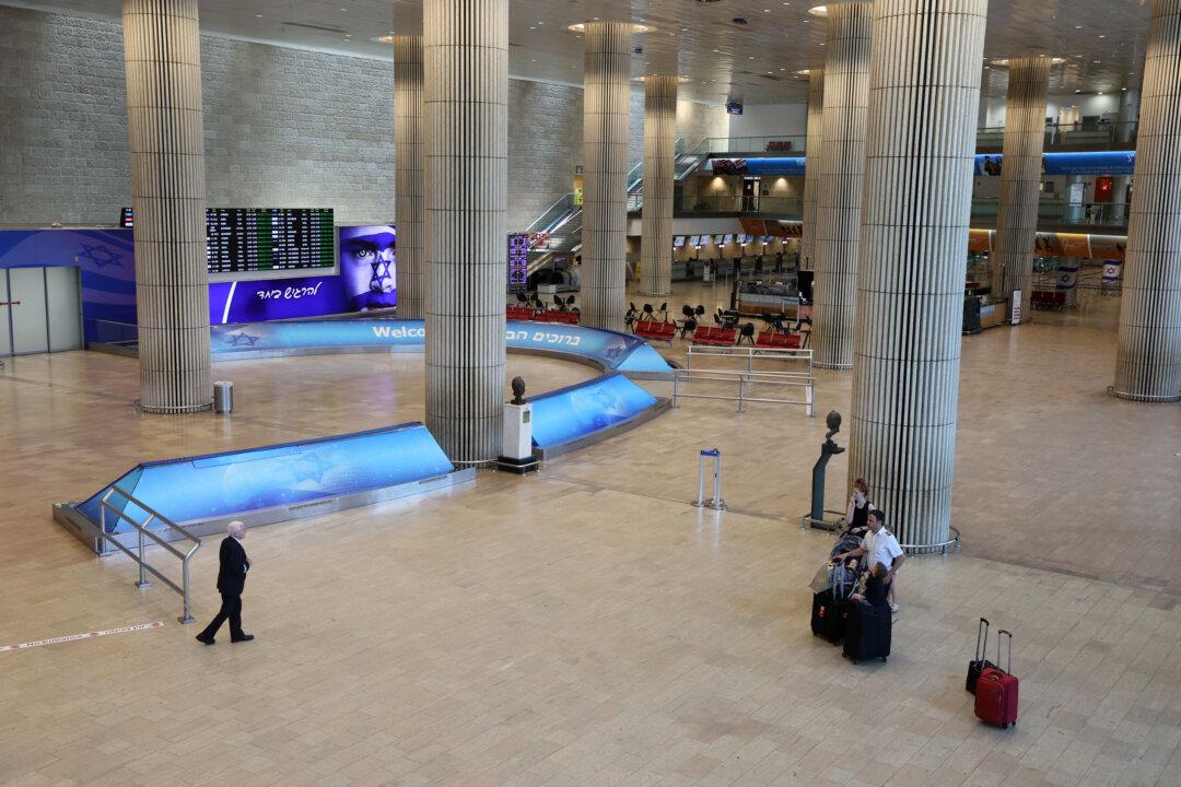 A few travelers stand at Ben Gurion Airport near Tel Aviv on June 13, 2025, after Israel closed its air space to takeoff and landing. Israel pounded Iran in a series of air raids on June 13, striking 100 targets including Tehran's nuclear and military sites, and killing the armed forces' chief of staff, the head of Iran's Revolutionary Guards, and top nuclear scientists. Iran launched 100 drones in response toward Israel, whose defenses were working to intercept them, the Israeli military said. (Gil Cohen-Magen/AFP via Getty Images)
