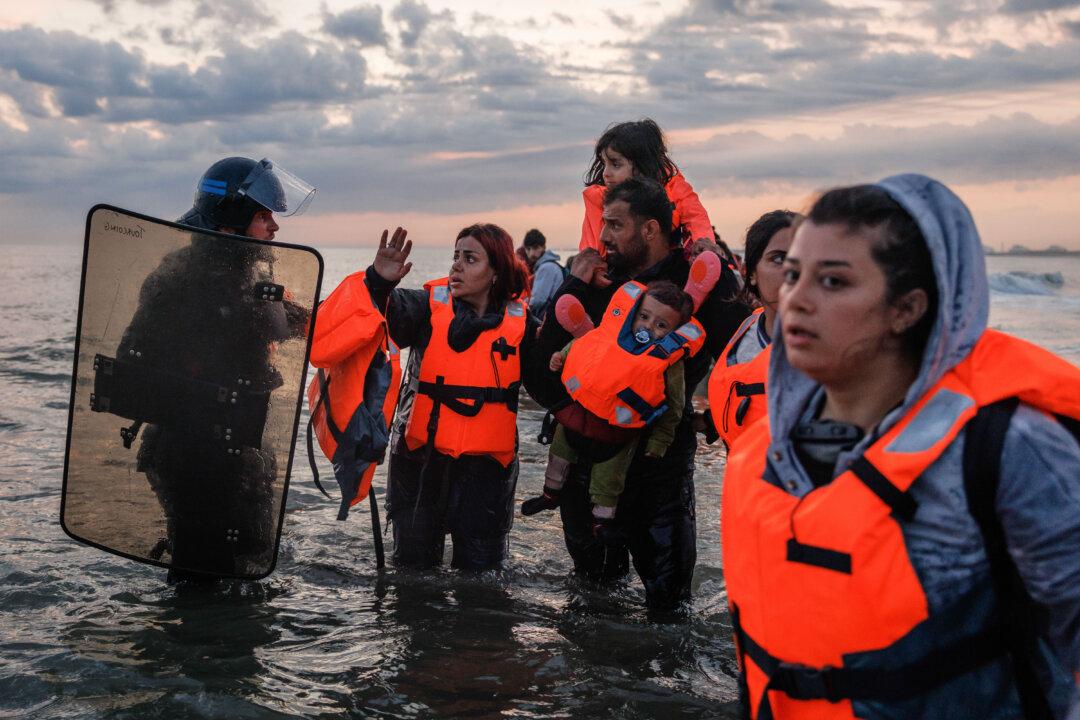 French police enter the water to try to stop migrants boarding small boats that had come to collect them from down the coast in Gravelines, France, on June 13, 2025. Police used tear gas and pepper spray to disperse hundreds of migrants aiming to board several boats, but were ultimately overwhelmed by the sheer number of people. A record number of migrants have left the northern French coastline and arrived in the UK so far this year, with figures surpassing the 15,000 mark. (Dan Kitwood/Getty Images)