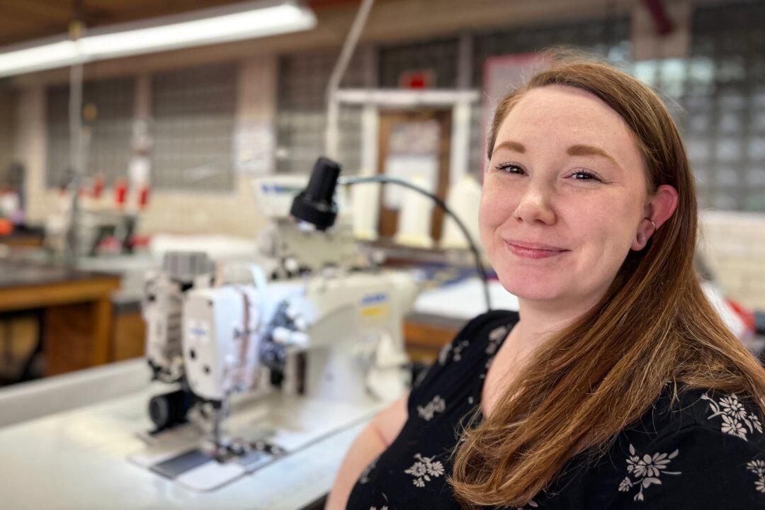 Lindsay Briede sits beside a sewing machine at the National Flag Company in Cincinnati on June 6, 2025. She started at the company as a teenager and has worked there for more than a decade. (Nathan Worcester/The Epoch Times)