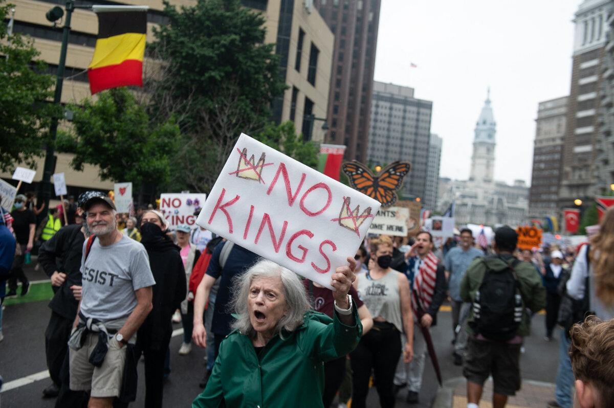 A protestor holds a placard during a march down the Benjamin Franklin Parkway to the Philadelphia Museum of Art during a nationwide "No Kings" rally in Philadelphia, Pennsylvania, on June 14, 2025. (Erin Blewett /AFP via Getty Images)