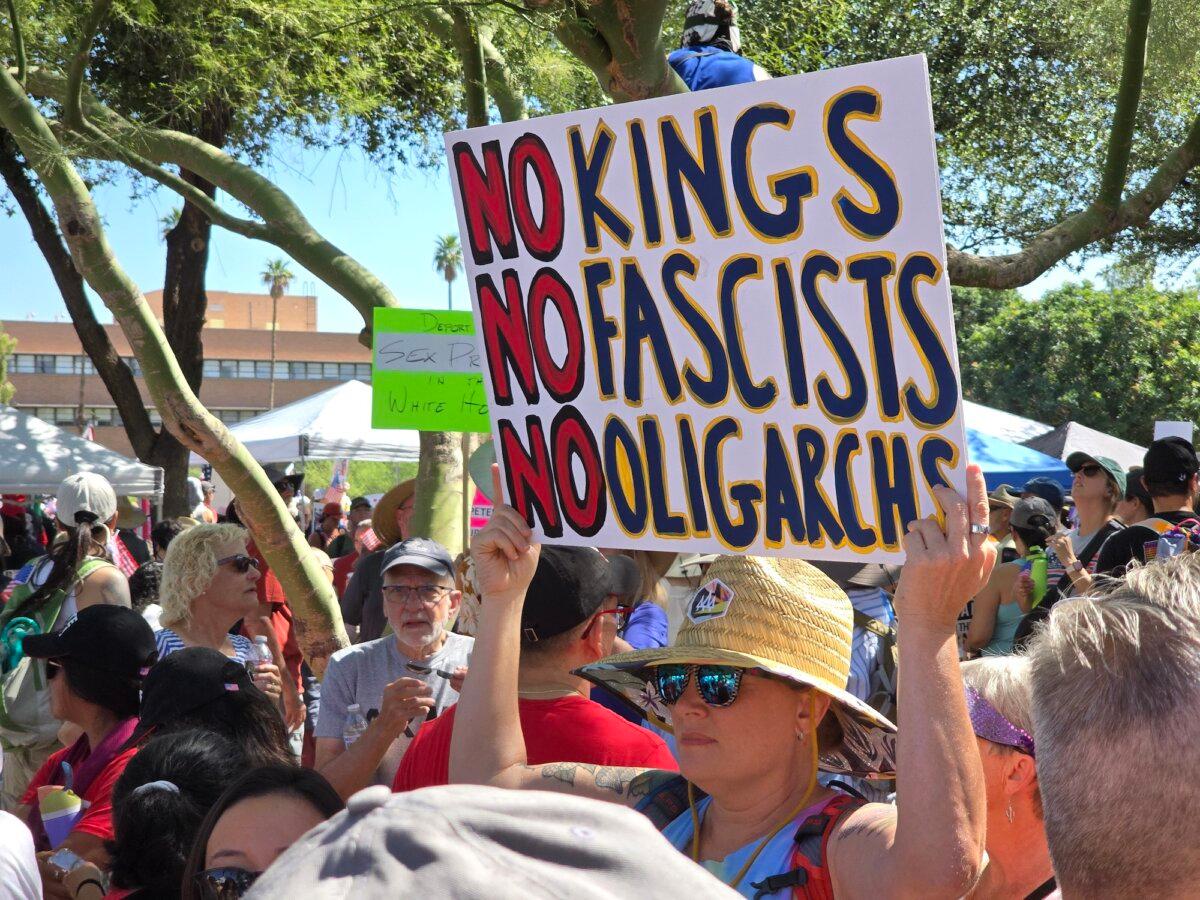 A woman holds an anti-Trump sign in Phoenix, Ariz., on June 14, 2025. (Allan Stein/The Epoch Times)
