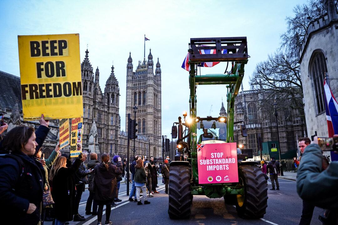 Farmers drive tractors past the Palace of Westminster during a Save British Farming protest in London on March 25, 2024. The demonstration opposed UK food policy, substandard imports, and stricter labeling rules, with farmers calling for action to protect British agriculture. (Henry Nicholls/AFP via Getty Images)